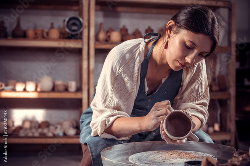 Stylish ceramist master molding a vase of clay on a potter's wheel. Pottery workshop.