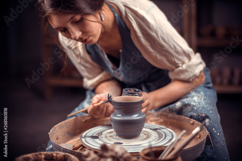 Charming female master sculpts from clay. The concept of craft creativity.