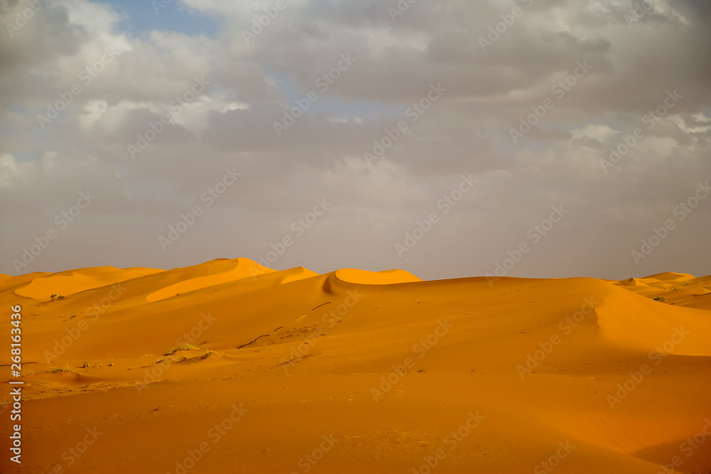 Sand dunes and dramatic clouds in the Sahara Desert in MOrocco