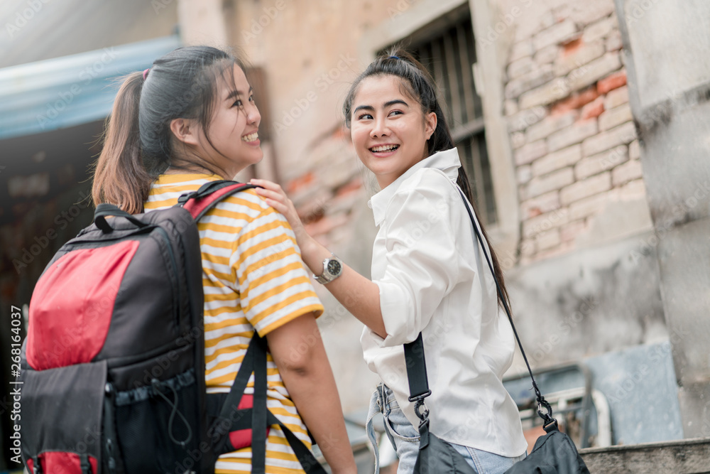 Asian woman and friend traveling to the old city in summer, She smiling and put her hand on friend shoulder.
