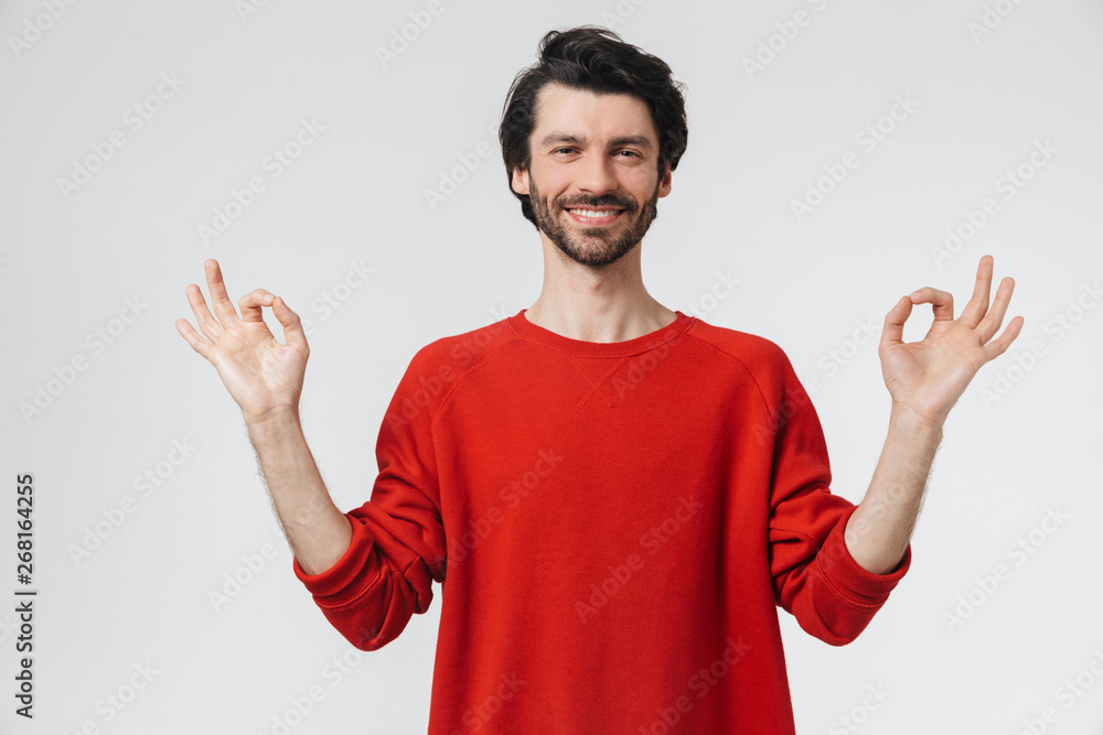 Handsome young concentrated man posing isolated over white wall background meditate. Handsome young concentrated man posing isolated over white wall background meditate.