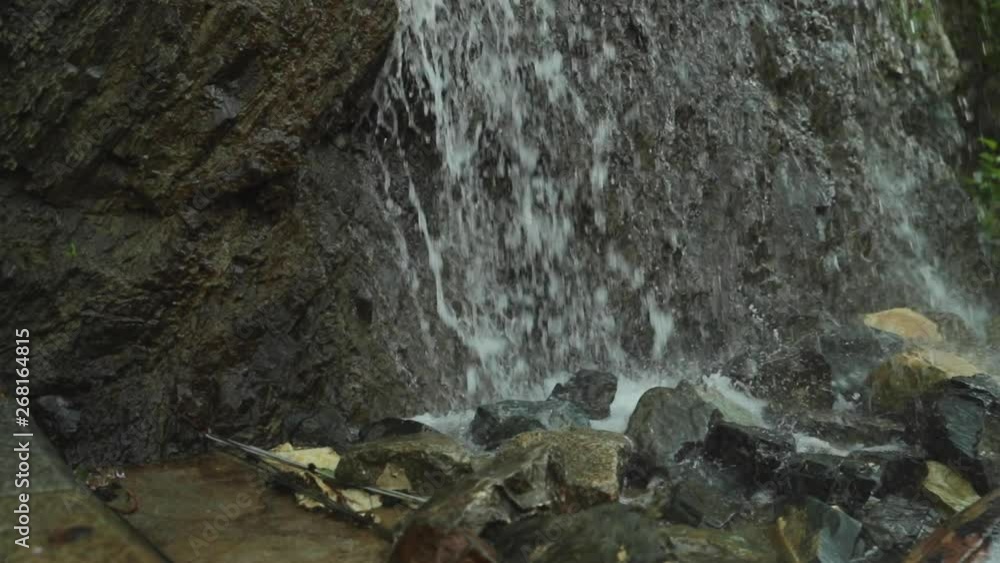 Water falling on stones in fountain captured in slow motion with water splash on rocks Water falling on stones in fountain captured in slow motion with water splash on rocks