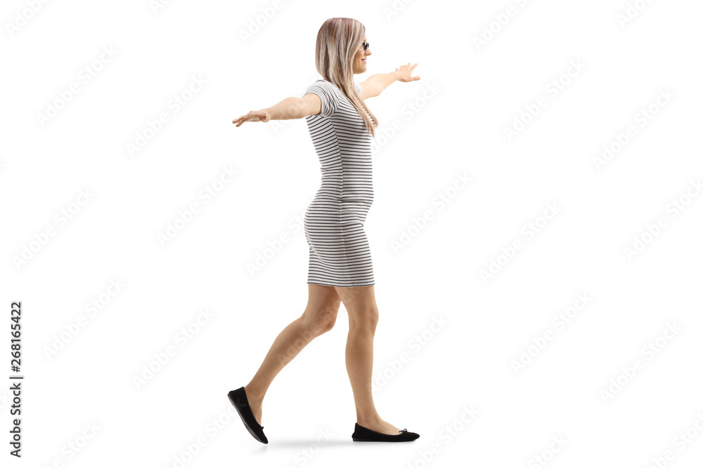 Young blond woman walking with arms spread