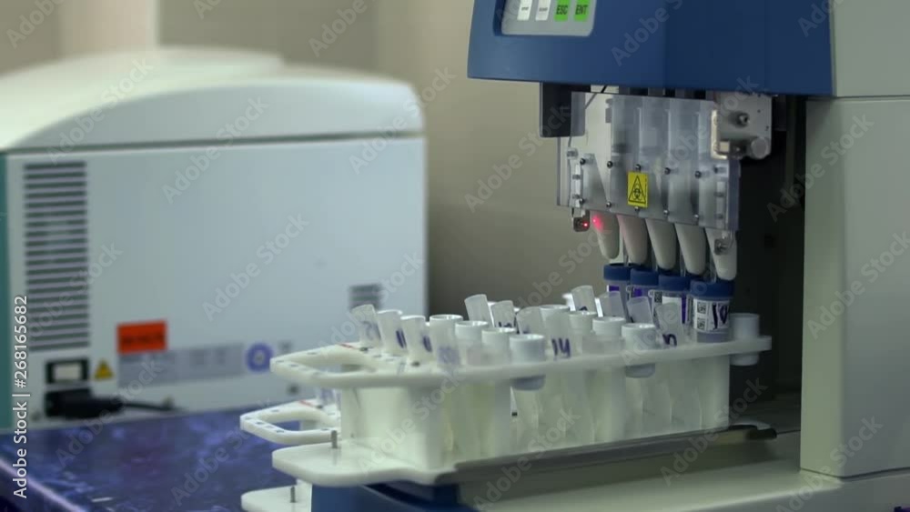 Automatic work with analysis in the laboratory. Electronic equipment in the lab working with test tubes close up. Drug manufacturing. Machinery in researching. Science, profession, healthcare Automatic work with analysis in the laboratory. Electronic equipment in the lab working with test tubes close up. Drug manufacturing. Machinery in researching. Science, profession, healthcare