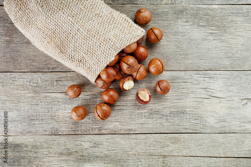 Macadamia nut on a wooden table in a bag, closeup, top view photo