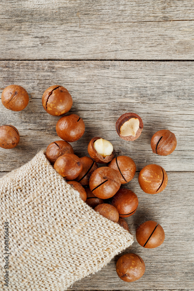Macadamia nut on a wooden table in a bag, closeup, top view Macadamia nut on a wooden table in a bag, closeup, top view