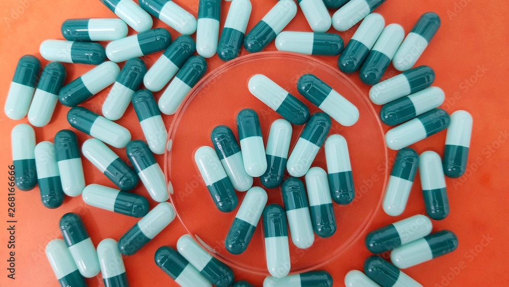 Green capsules on orange background Green capsules on orange background