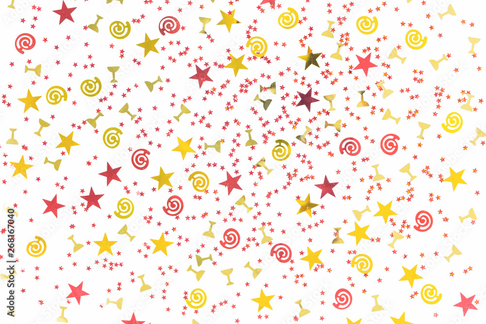 Golden stars and flutes and swirls glitter and assorted sparkling confetti partially blurred isolated on white background. Festive holiday pastel backdrop Golden stars and flutes and swirls glitter and assorted sparkling confetti partially blurred isolated on white background. Festive holiday pastel backdrop