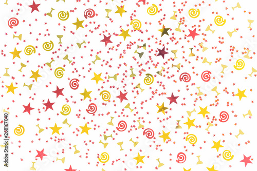 Golden stars and flutes and swirls glitter and assorted sparkling confetti partially blurred isolated on white background. Festive holiday pastel backdrop