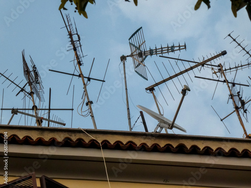 Rooftop Tv antennas against blue sky