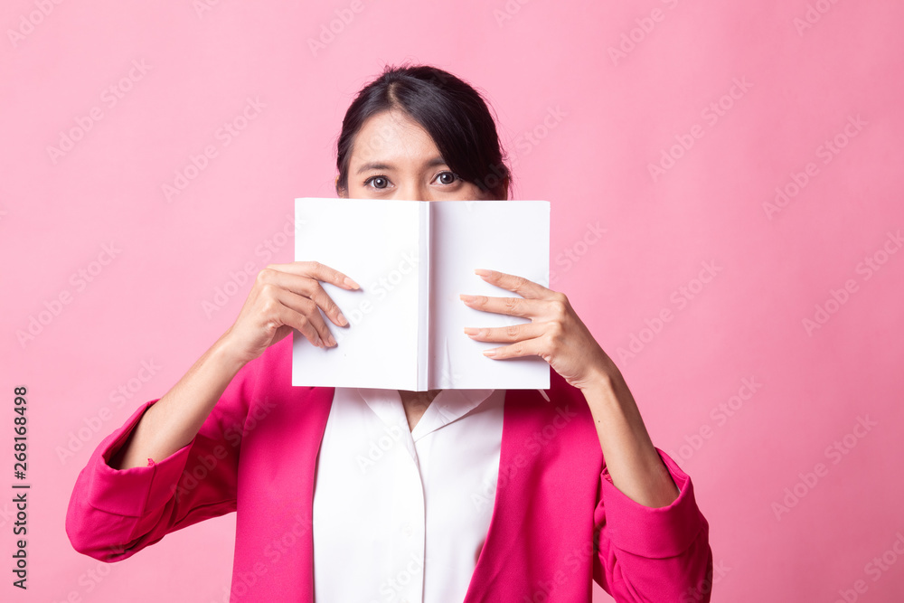 Young Asian woman with a book cover her face. Young Asian woman with a book cover her face.