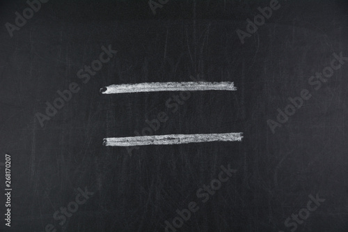 Equal sign, symbol on black chalkboard
