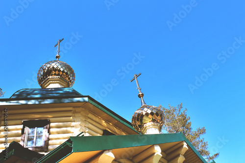 Golden domes with crosses on the  temple church chapel, a religious christian building of wooden logs bottom view photo