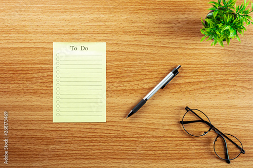 empty to do list and a pen on wooden desk.