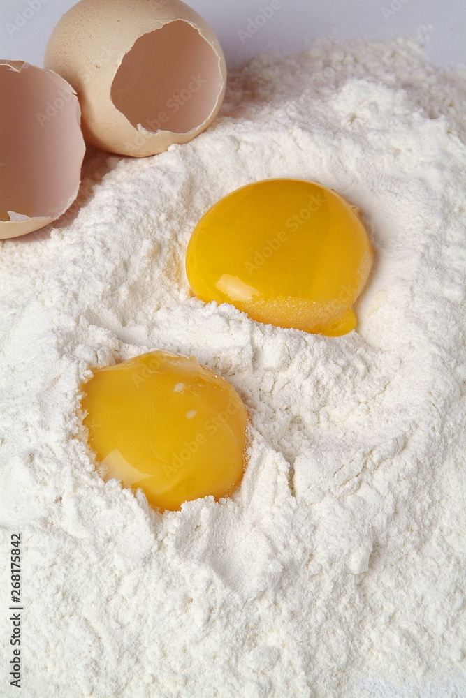 Broken eggs isolated over the flour Broken eggs isolated over the flour