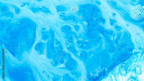 Abstract blue paint background. Color gradient fluid flowing similar to river system covering rough uneven glitter surface. © golubovy