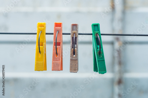 old colored clothespins hanging on a wire for drying clothes. Clothespins on blurred background