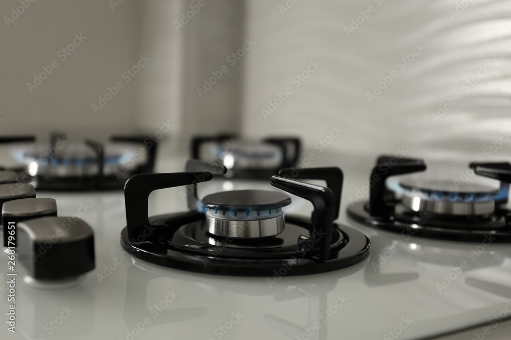 Gas burners with blue flame on modern stove, closeup Gas burners with blue flame on modern stove, closeup