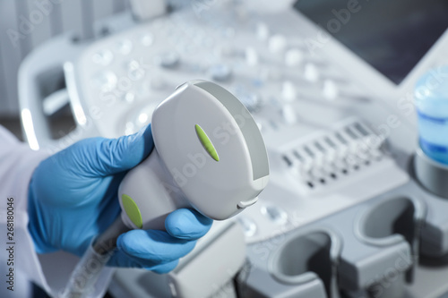 Obraz na plátně Sonographer holding ultrasound machine probe in clinic, closeup with space for t