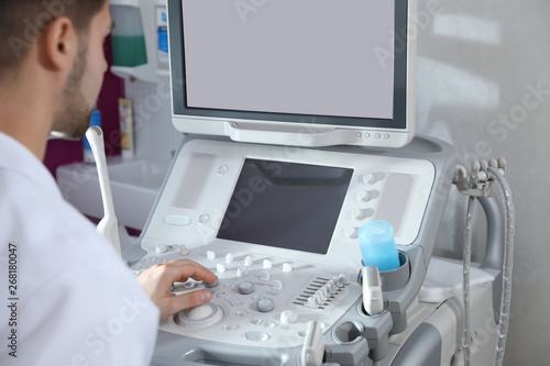Sonographer using modern ultrasound machine in clinic