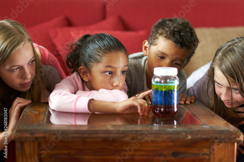 4 kids doing science experiment,learning about density and physical properties of liquids