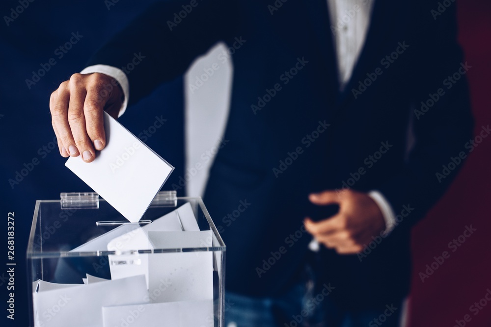 Elections in France. Man throwing his vote into the ballot box.