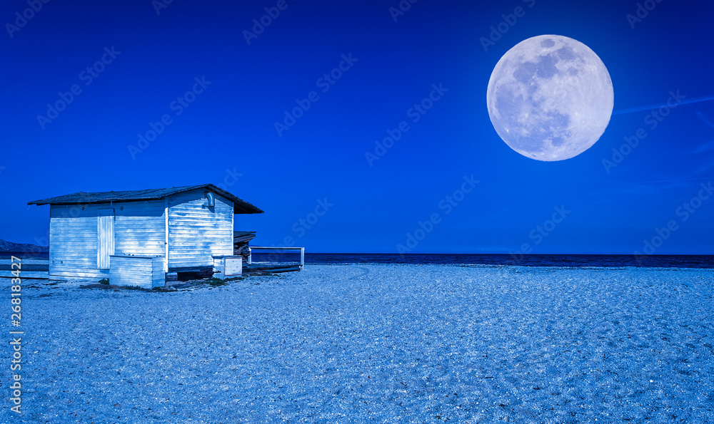 White cottage on the beach at night