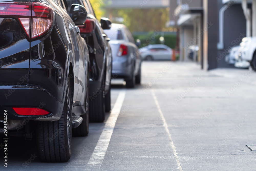 Black car parked in a row on the road, outdoor parking.