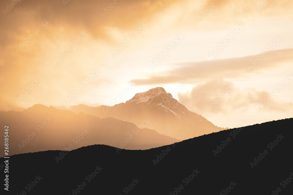 Montagne dans la brume éclairée par le soleil couchant
