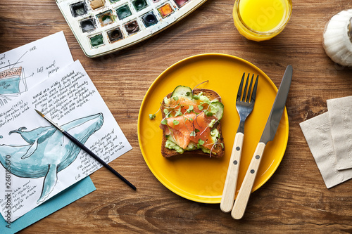 Plate with delicious sandwich with avocado and salmon with sketc photo