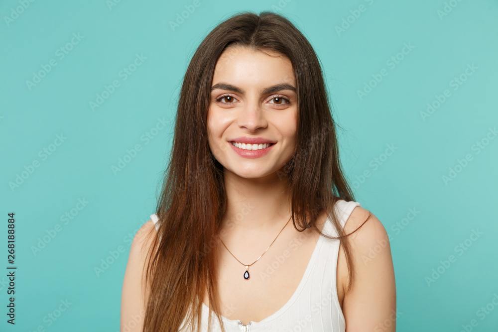 Portrait of smiling attractive young woman in light casual clothes looking camera isolated on blue turquoise wall background in studio. People sincere emotions, lifestyle concept. Mock up copy space. Portrait of smiling attractive young woman in light casual clothes looking camera isolated on blue turquoise wall background in studio. People sincere emotions, lifestyle concept. Mock up copy space.