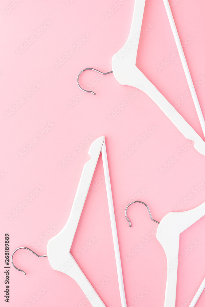 White hangers on pastel pink background