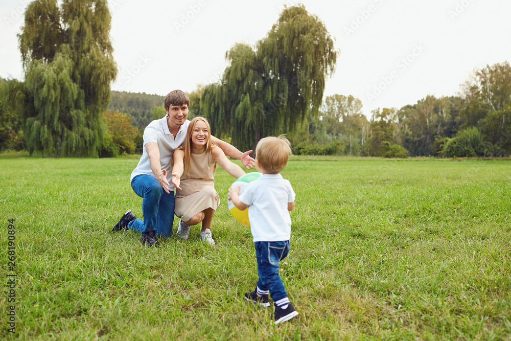 Happy family playing on the grass in the park. 