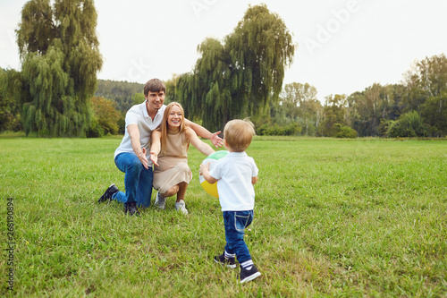 Happy family playing on the grass in the park. 