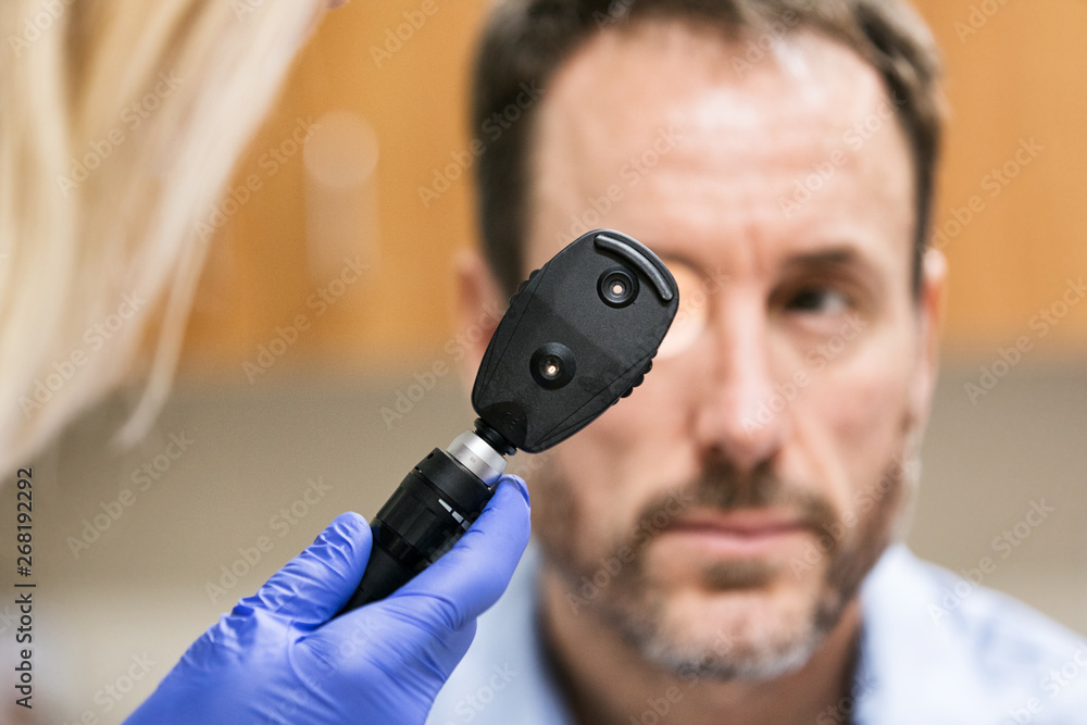 Clinic Doctor Using Ophthalmoscope To Check Patient Stock Photo