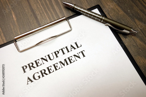 Clipboard with prenuptial agreement and pen on desk photo