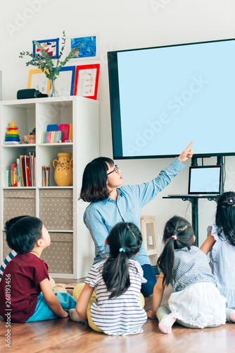 Teacher and preshool kids in classroom photo