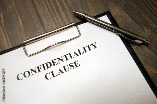 Fotografie Clipboard with confidentiality clause and pen on desk