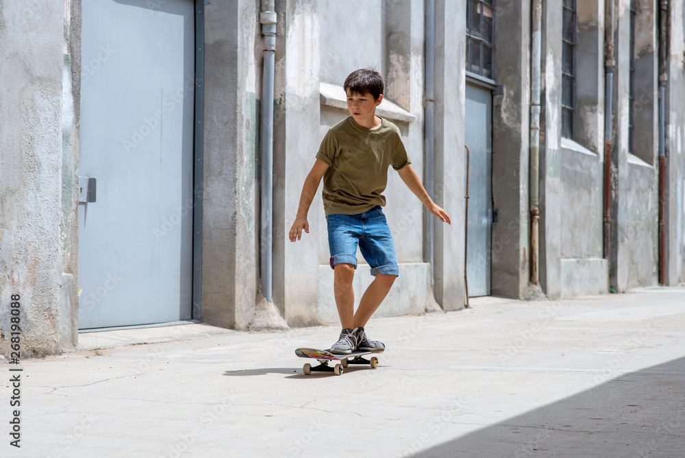 Front view of cheerful skater boy riding on the city in a sunny day