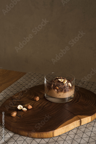 Chocolate cream in a cup with hazelnuts photo