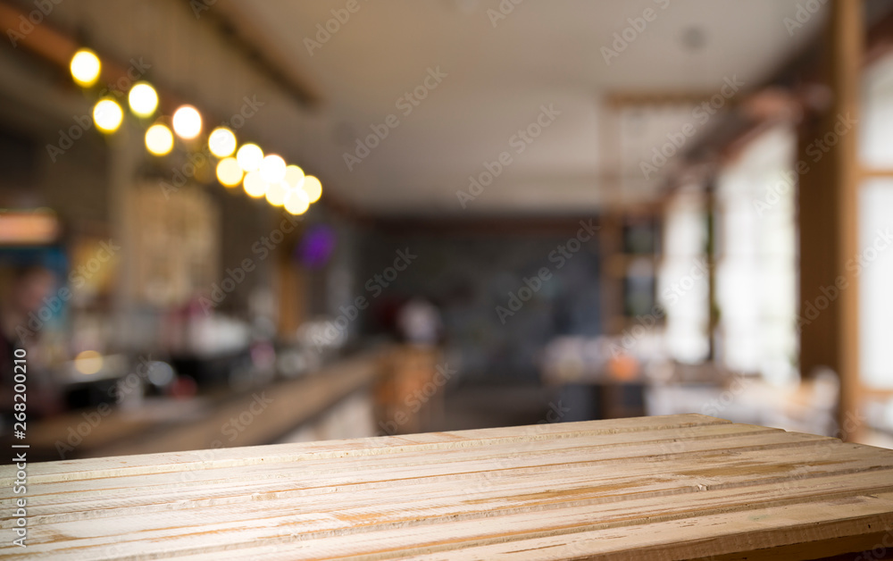 image of wooden table in front of abstract blurred background of resturant lights image of wooden table in front of abstract blurred background of resturant lights