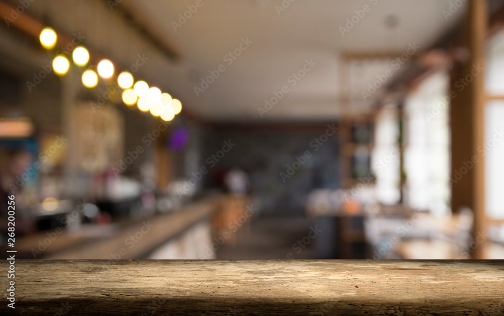 image of wooden table in front of abstract blurred background of resturant lights