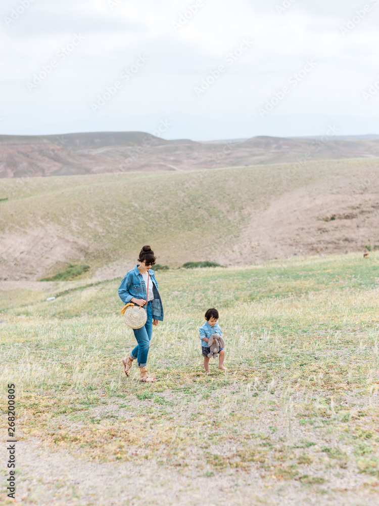 Mom and baby walking in grassy field landscape Mom and baby walking in grassy field landscape