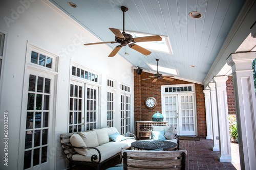 Outdoor Residential Back Patio Porch with Couches and Chairsand a Table photo