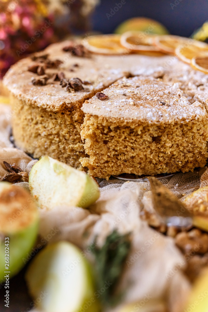Biscuit apple pie with cinnamon, citron, oriental spices and sugar powder on dark background Biscuit apple pie with cinnamon, citron, oriental spices and sugar powder on dark background