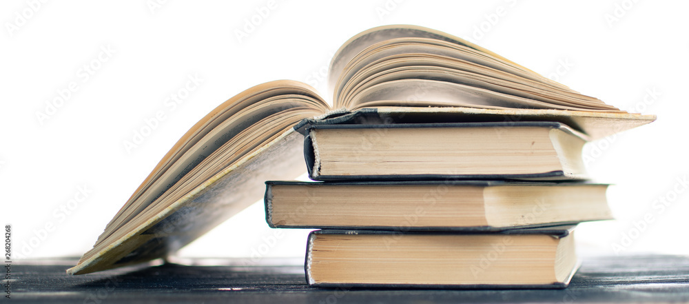 Naklejka premium Heap pile of rare books. Open book, hardback books on wooden table. Education background. Back to school. Copy space for text. Bestseller, business. Stack books and red bookmark