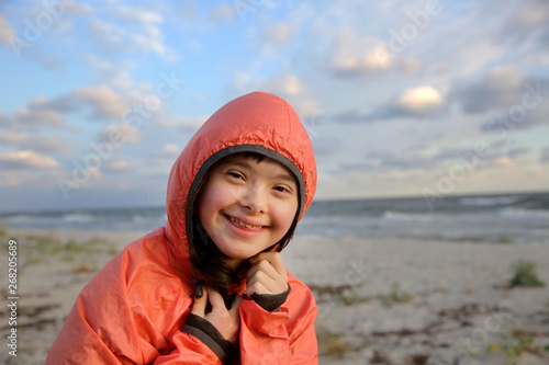 Portrait of down syndrome girl smiling on background of the sea © denys_kuvaiev
