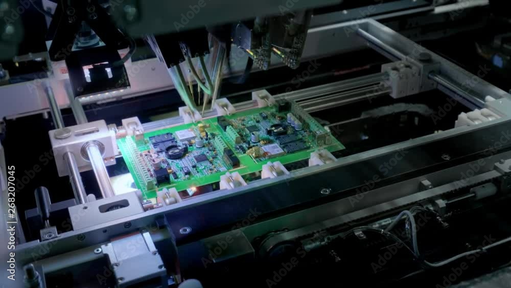 Factory Machine at Work: Printed Circuit Board Being Assembled with Automated Robotic Arm, Surface Mounted Technology Connecting Microchips to the Motherboard. Time Lapse Macro Close-up Footage Factory Machine at Work: Printed Circuit Board Being Assembled with Automated Robotic Arm, Surface Mounted Technology Connecting Microchips to the Motherboard. Time Lapse Macro Close-up Footage