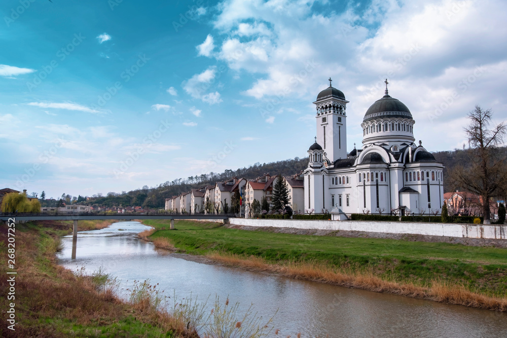 Wide view of The Holy Trinity Church in Sighisoara, and the river Tarnava Mare.