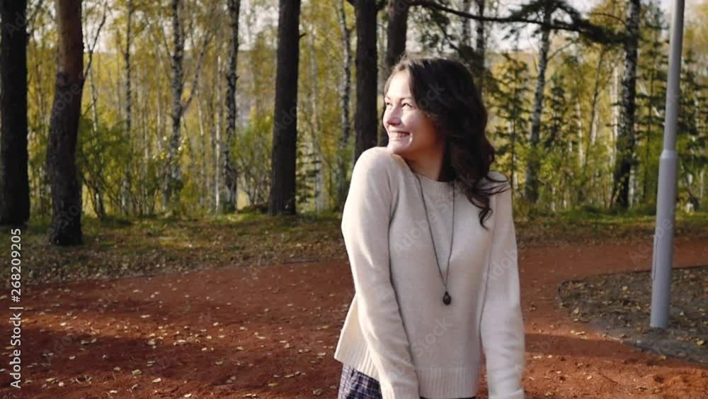 A young woman walks in the autumn park. brunette woman jumping and dancing in the forest. freedom concept A young woman walks in the autumn park. brunette woman jumping and dancing in the forest. freedom concept